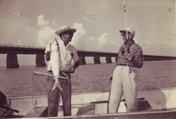In an undated photo, angler and guide show off a tournament bonefish, with the historic Old Seven Mile Bridge in the background. Today, catch-and-release is a standard fishing practice.